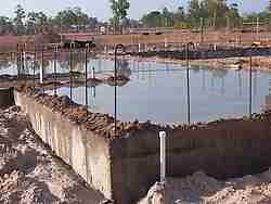 Curing a concrete house slab by flooding