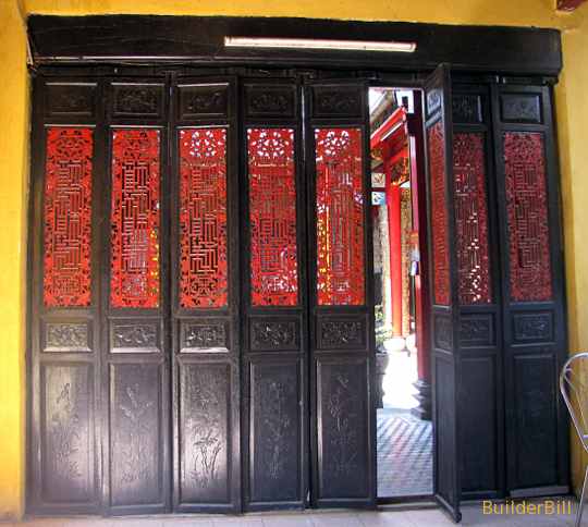 A timber door screen of pivoting doors