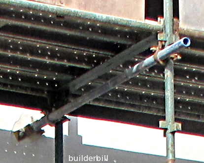 a putlog securing a section of scaffold to a wal